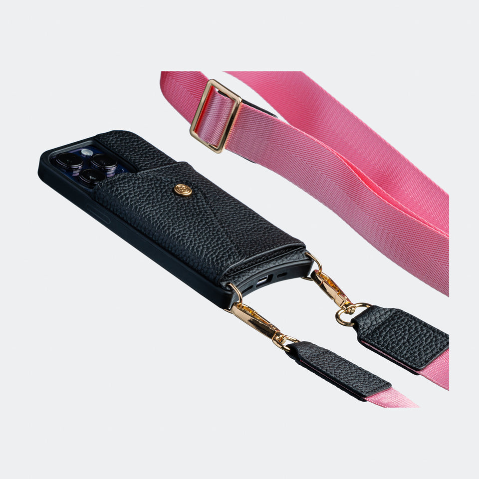 Black Bandolier-style Side angle view of a black leather crossbody phone case, highlighting the adjustable pink nylon and leather strap and slim profile